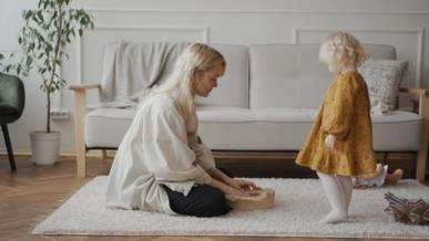 A parent and child playing together on a rug