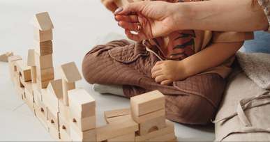 A child's hands stacking wooden blocks
