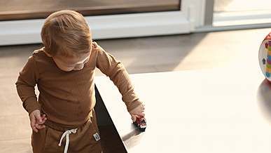 A toddler playing in a sunlit living room